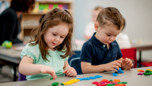 Two children playing with letters
