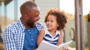 Man reading a book to a girl